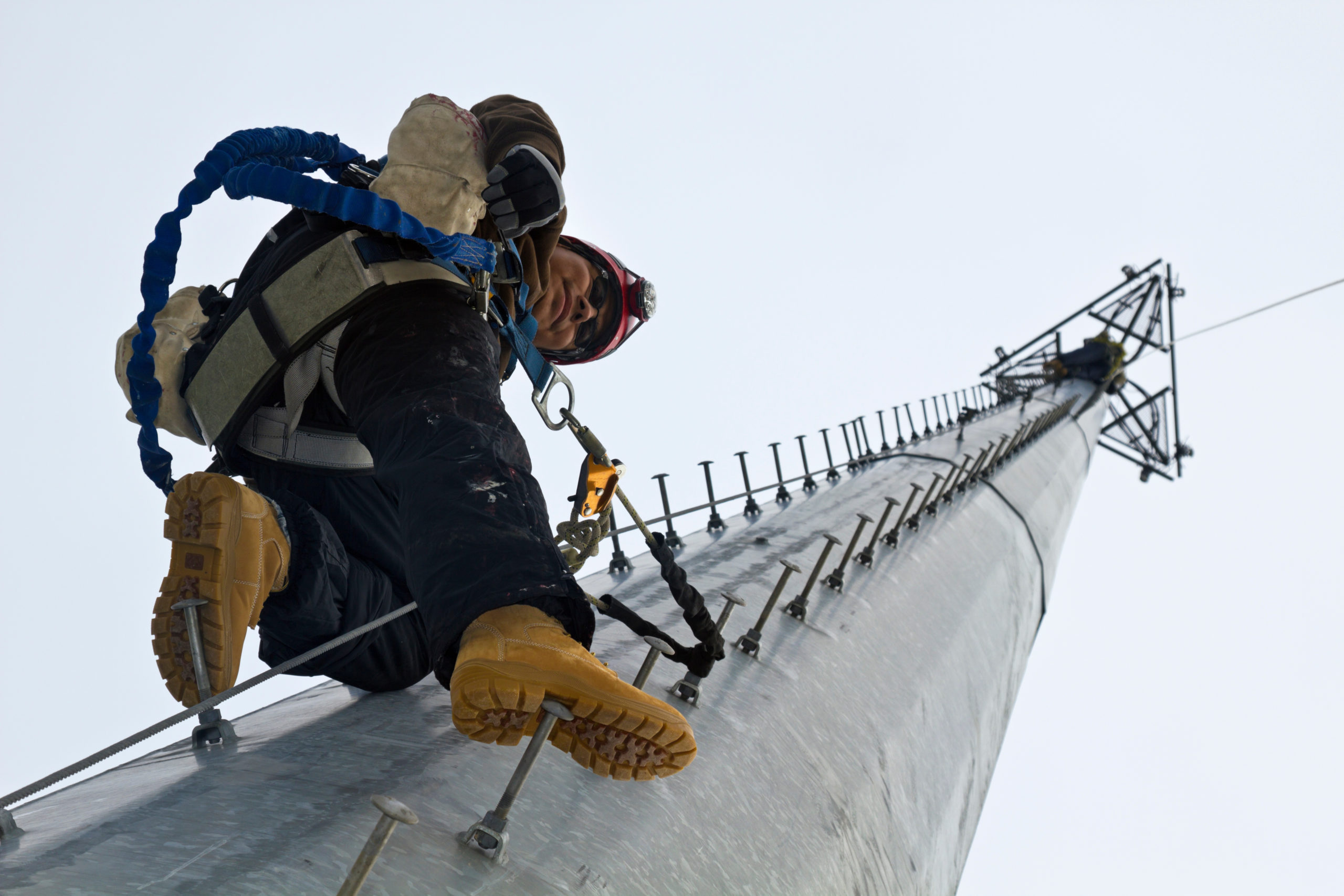 A man ascending a cell tower for work.