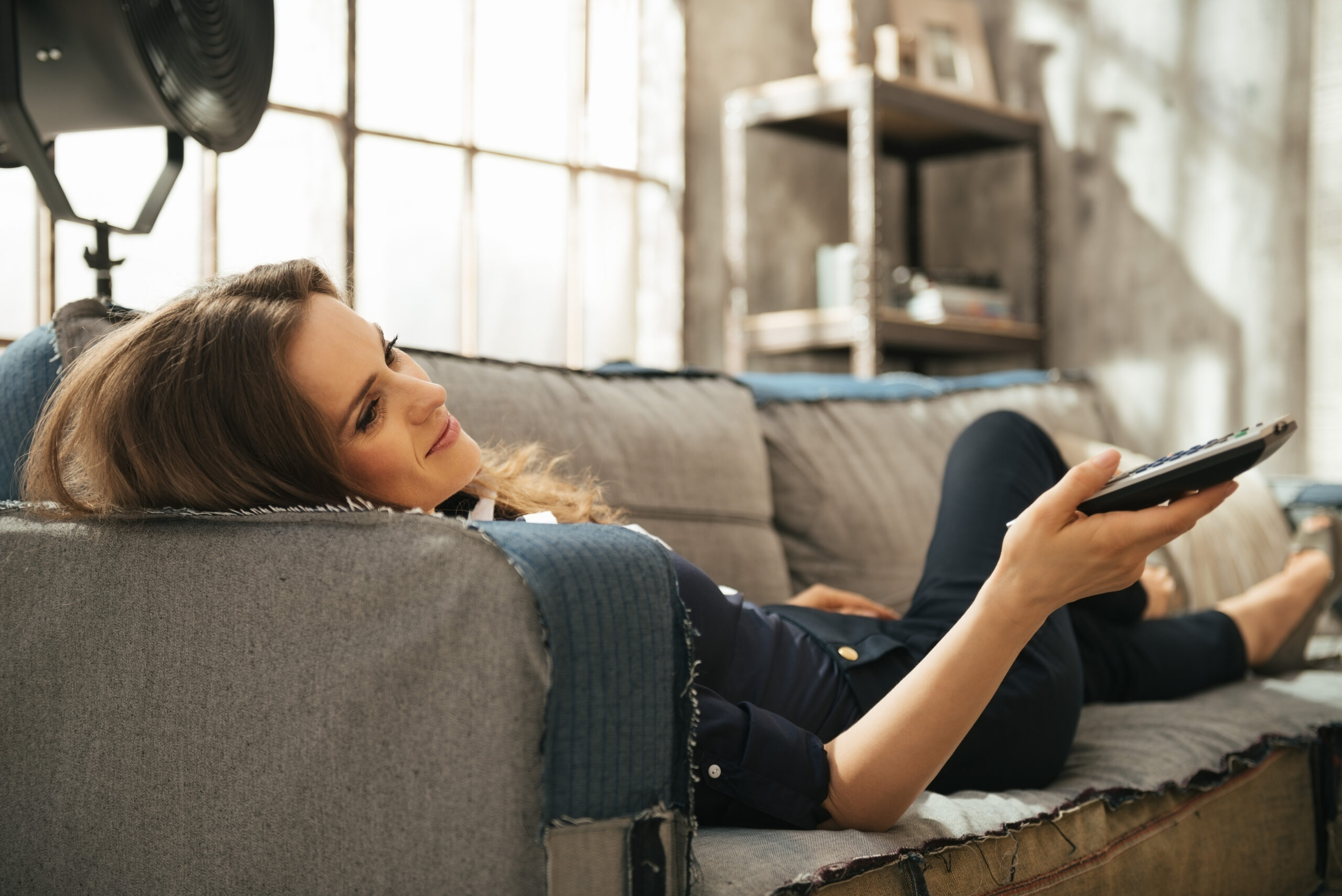 Relaxed young brunette woman lying on sofa